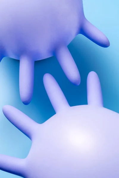 Two Purple Inflated Latex Gloves Vibrant Blue Background Studio Closeup — Stok fotoğraf