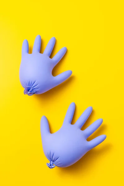 Pair Purple Inflated Latex Gloves Vibrant Yellow Background Studio Top — Φωτογραφία Αρχείου