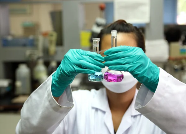 Assistente de laboratório analisando um líquido — Fotografia de Stock