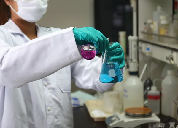 Assistente de laboratório analisando um líquido — Fotografia de Stock