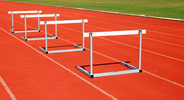running tracks with three hurdles set up for training