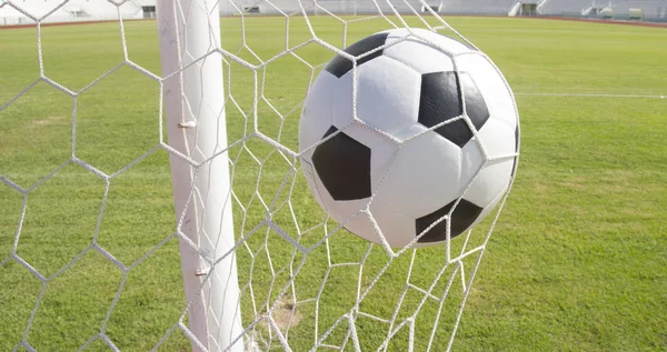 Voetbal voetbal in doel netto met groen grasveld — Stockfoto