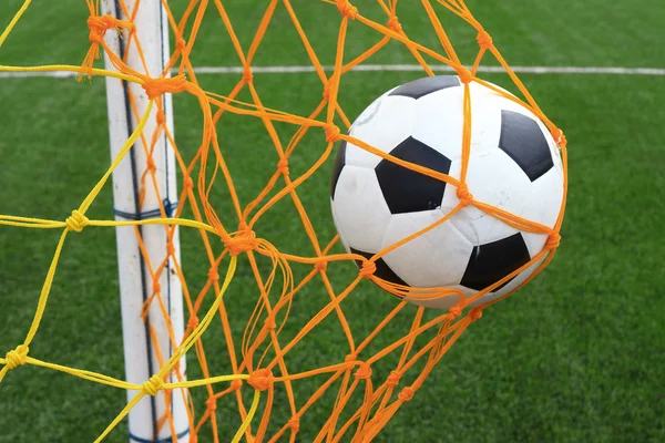 Fútbol fútbol en Goal net con campo de hierba verde — Foto de Stock