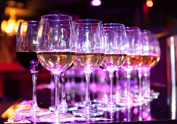 Brýle červené a bílé víno na stole Royalty Free Stock Fotografie