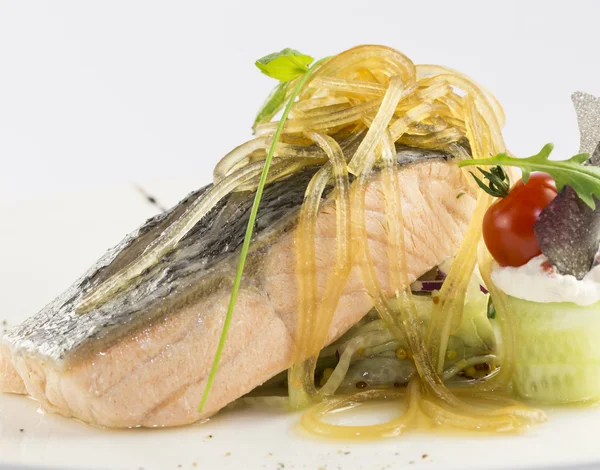 Gebackener Lachs mit Gemüse auf weißem Hintergrund im Restaurant — Stockfoto