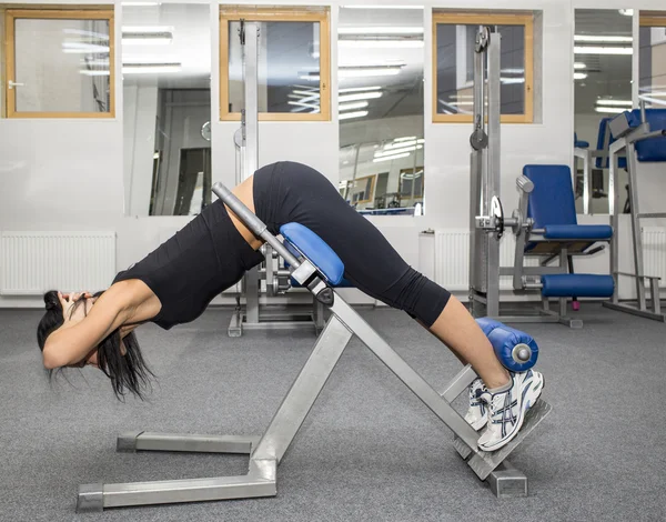 Atletische jonge vrouw werkt op simulator — Stockfoto