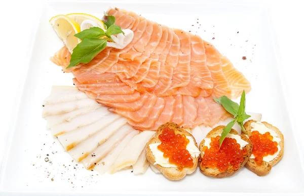 Mackor med kaviar och skivad fisk på en vit platta — Stockfoto