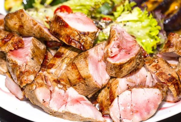 Carne asada a la parrilla con verduras en un plato de madera —  Fotos de Stock