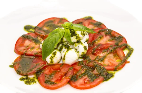 Tomates y queso en plato blanco en un restaurante — Foto de Stock
