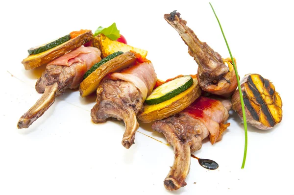 Grillat nötkött revben med grönsaker på en vit platta i en restaurang — Stockfoto