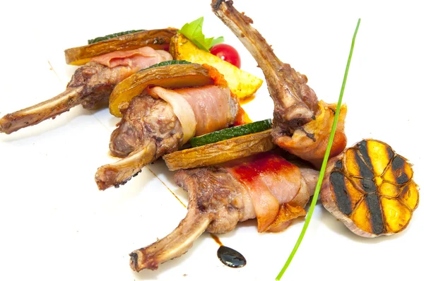 Жареные телячьи ребрышки с овощами на белой тарелке в ресторане — стоковое фото