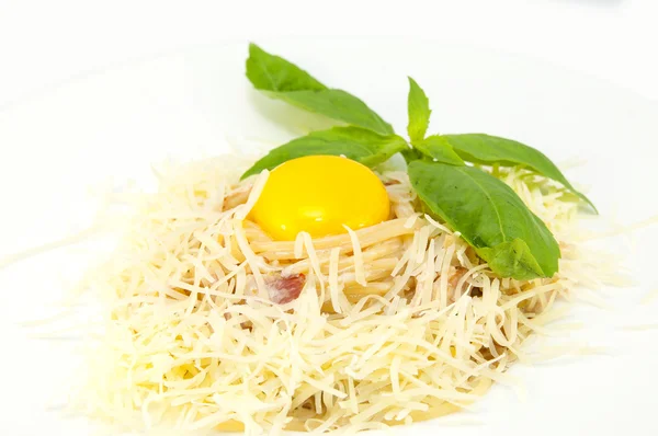Спагетти с сыром и яйцом на белой тарелке в ресторане — стоковое фото