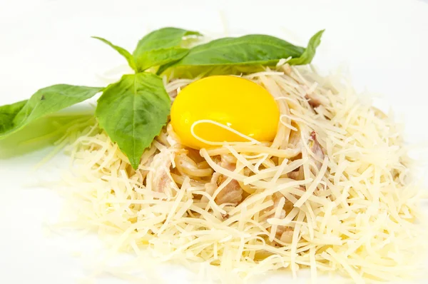 Spagetti med ost och ägg på en vit platta i en restaurang — Stockfoto