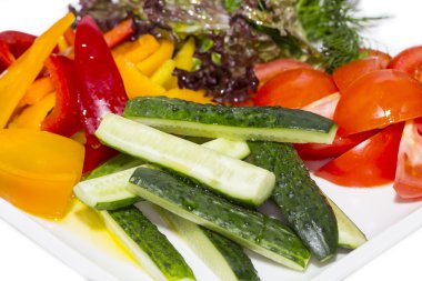 bir tabloda bir restoranda beyaz tabakta domates ve salatalık