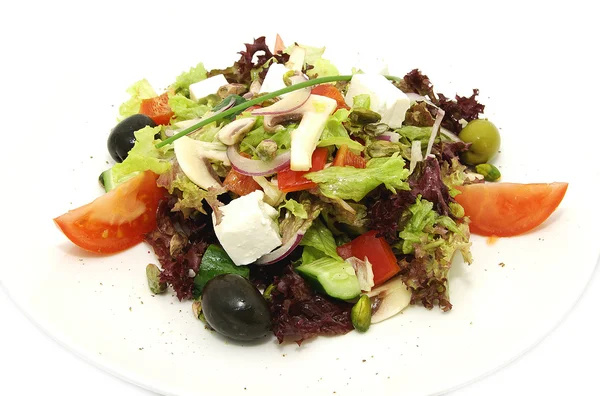 Греческий салат на белой тарелке в ресторане — стоковое фото