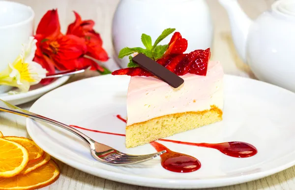 Sobremesa, um pedaço de bolo na mesa com uma xícara de chá — Fotografia de Stock
