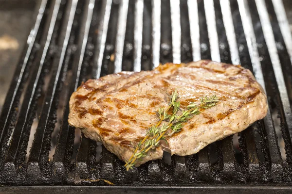 Cooking beef steak on a grill in the restaurant — Stock Photo, Image