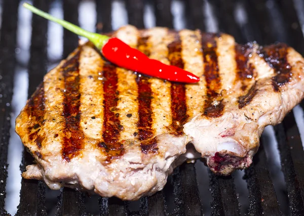Cooking beef steak on a grill in the restaurant — Stock Photo, Image
