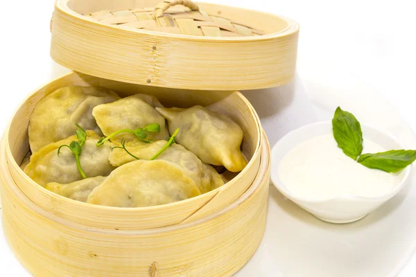Dumplings with sour cream in a wooden bowl — Stock Photo, Image