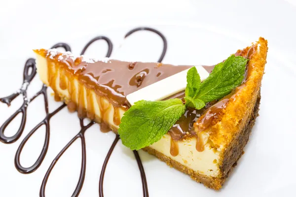 A piece of cheese cake decorated with mint leaves — Stock Photo, Image