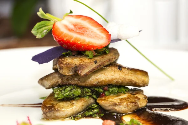 Roast goose liver is decorated with greens and strawberries — Stock Photo, Image