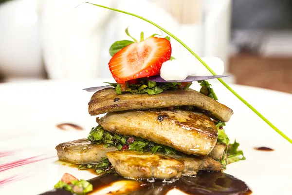 Roast goose liver is decorated with greens and strawberries — Stock Photo, Image