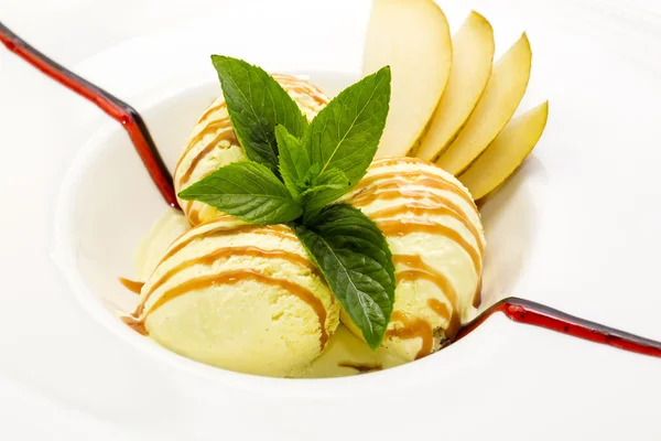 Helado con salsa de caramelo y menta sobre fondo blanco — Foto de Stock