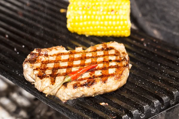 Cooking beef steak on a grill in the restaurant — Stock Photo, Image