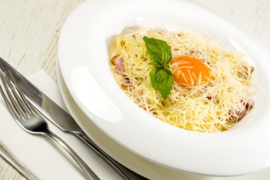 spagetti yumurta ve peynir bir tablo içinde bir restoran ile