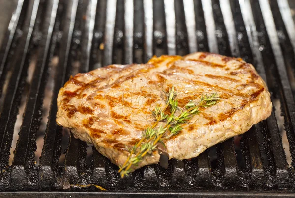 Cooking beef steak on a grill in the restaurant — Stock Photo, Image