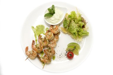 sebze ve limon ile beyaz bir tabak karides şiş