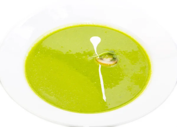 Sopa de ervilha decorada com cogumelos e verde em uma placa branca em um restaurante — Fotografia de Stock