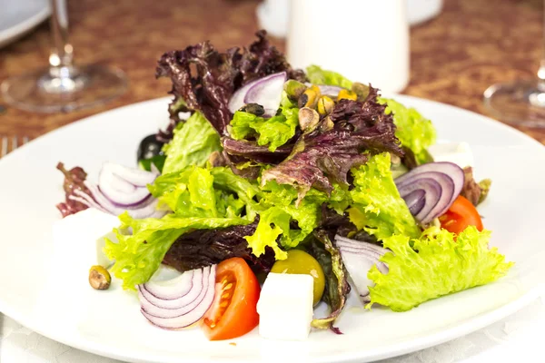 Греческий салат на белом фоне в ресторане — стоковое фото