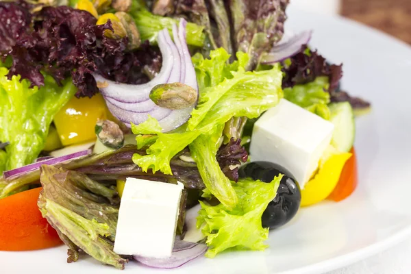 Greek salad on a white background in the restaurant — Stock Photo, Image
