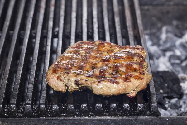 Cooking beef steak on a grill in the restaurant — Stock Photo, Image