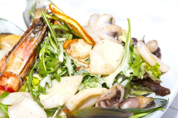 एक रेस्तरां में टेबल पर सब्जियों और समुद्री भोजन के साथ सलाद — स्टॉक फ़ोटो, इमेज