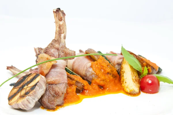 Gebraden kalfsvlees ribben met groenten op een witte plaat in een restaurant — Stockfoto