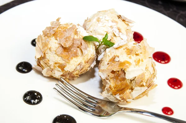 Boules de crème glacée décorées à la menthe sur fond blanc dans le restaurant — Photo