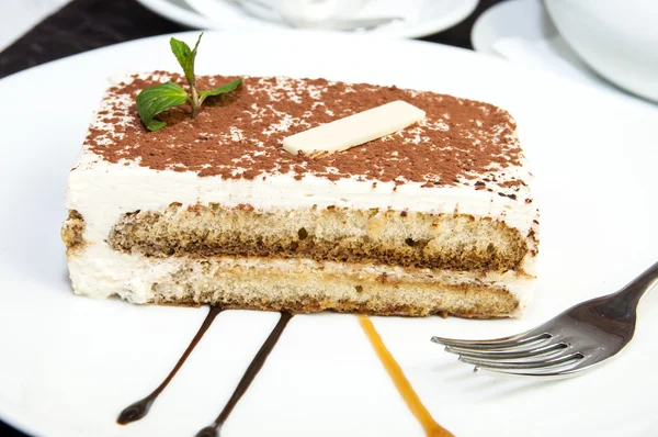 Tiramisu on a white plate in a restaurant — Stock Photo, Image