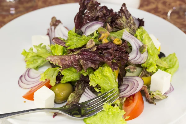 Grekisk sallad på vit bakgrund i restaurangen — Stockfoto