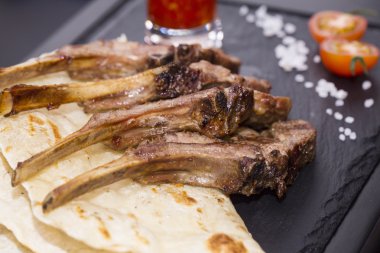 ızgarada pişmiş kuzu kaburga sıcak bir taş üzerinde devam eder.