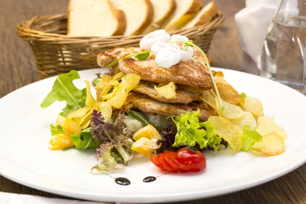 Ensalada con pollo y patatas en un plato blanco en un restaurante —  Fotos de Stock