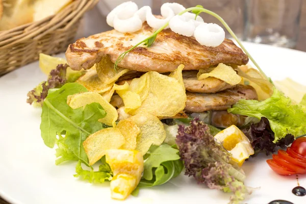 Salat mit Hühnchen und Kartoffeln auf einem weißen Teller in einem Restaurant — Stockfoto