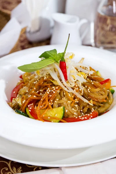 Espaguetis de arroz con verduras en un plato blanco en un restaurante — Foto de Stock