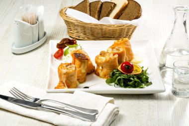 bir tabloda bir restoranda pişmiş somon böreği