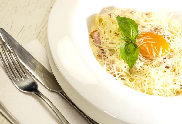 Spaghetti with egg on a table in a restaurant — Stock Photo, Image