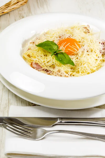 Spaghetti with egg on a table in a restaurant — Stock Photo, Image