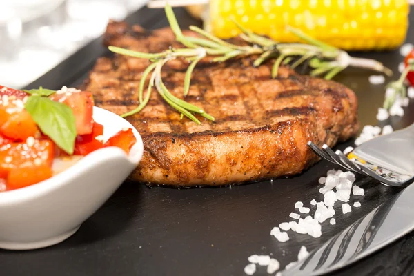 Una bistecca con verdure servita su una pietra calda — Foto Stock