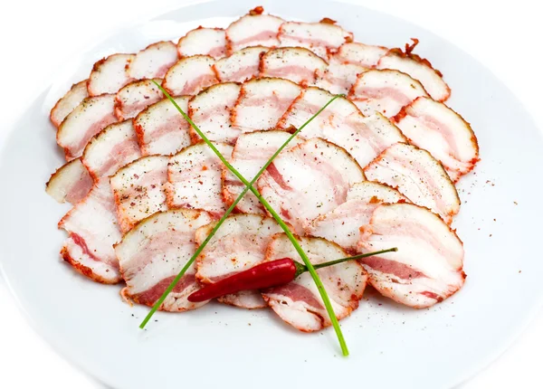 Bacon, cipolla e pepe su un piatto in un ristorante — Foto Stock