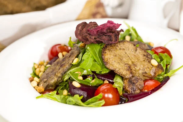 Rabbit liver salad with arugula in a restaurant — Stock Photo, Image